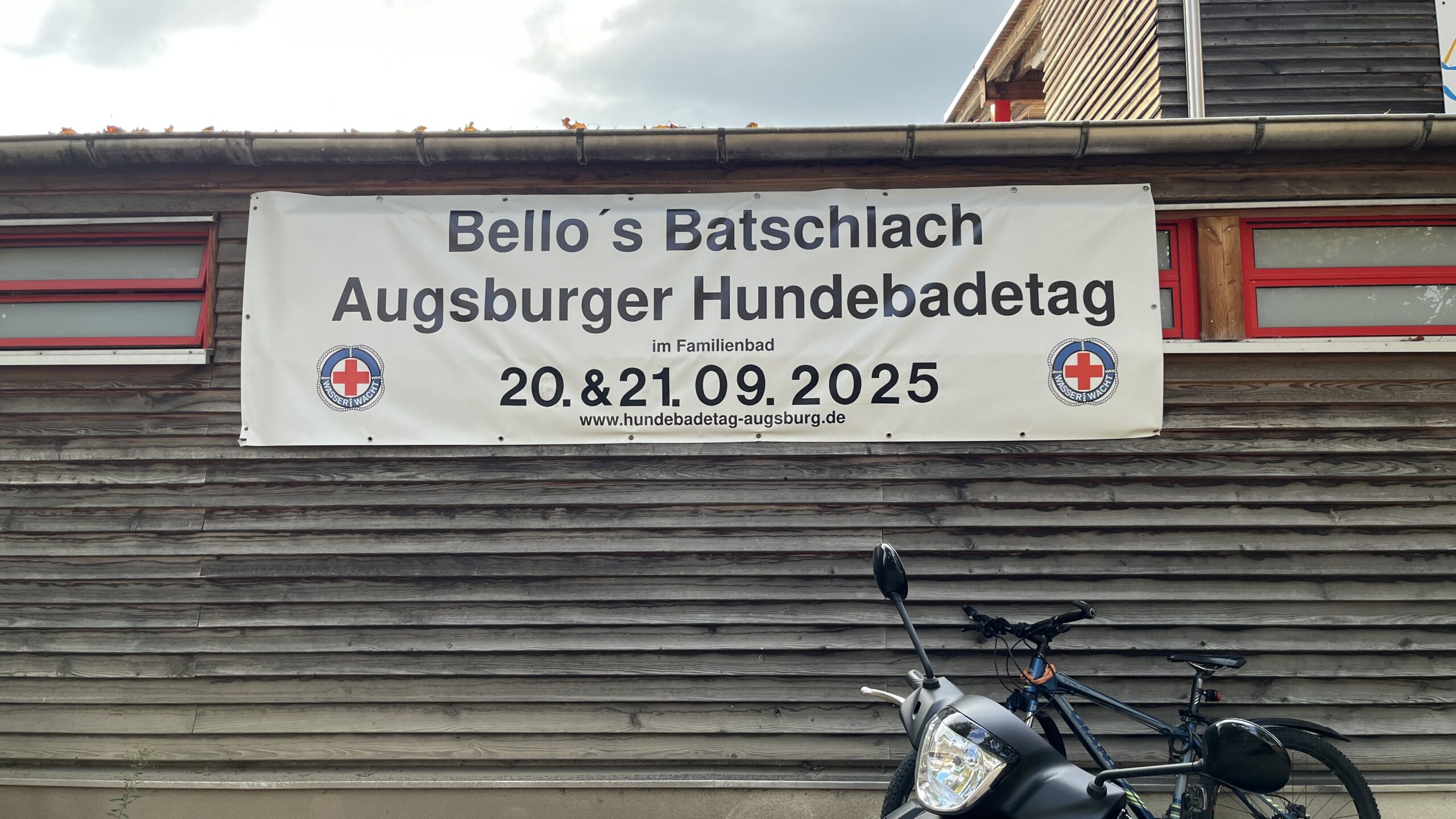 Plakat mit dem Schriftzug „Bello’s Badschlach - Augsburger Hundebadetag - 20 & 21.09.2925“ am Familienbad Augsburg